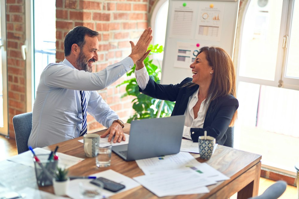 Two ThumbsClick specialists discussing an AI SEO visibility plan with a client